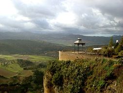 gazebo on a hill on a background of the cloudy sky