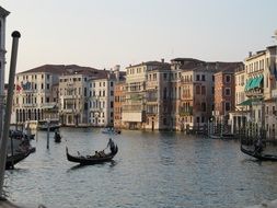 Tourists ride gondolas on canals in Venice