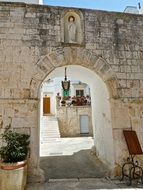 aged stone wall with arched gateway, Italy