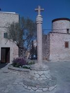 cross at top of column and tree on square, spain