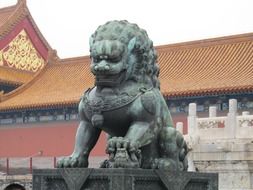 sculpture of a stone lion in front of a temple in China