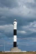 black-white lighthouse against a stormy sky