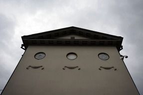 Facade of the building with round windows and relief