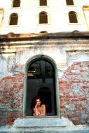 girl looks out of the window of a brick building