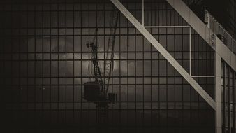 crane reflection on facade of a glass building