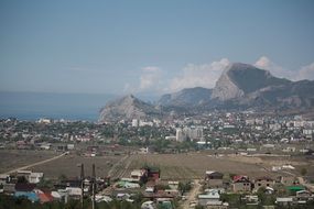 landscape of small houses on the background of mountains and the sea