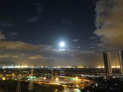 moon in the night sky over the city