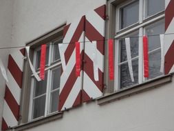 carnival garland at striped shutters on windows