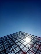 sun shining through steel and glass triangular construction