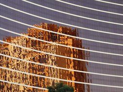 reflected in the glass facade of the building