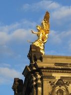 Shiny gold angel fig on roof in light