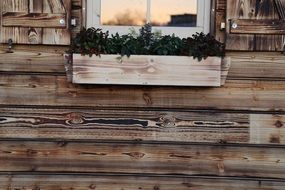 wooden facade of a house with window flowers