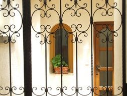 door and window of the house behind a figured fence