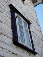 wooden window in black frame and blue sky