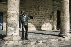 sculpture of man near the column in the city