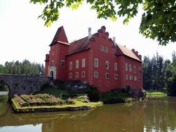 Red castle in lake in the Czech Republic