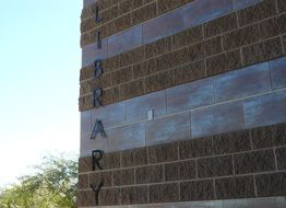 brick facade of the public library and trees at background