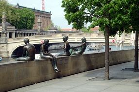 statues of girls on the river bank