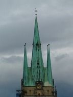 spiers of the copper roof of the church against the backdrop of the stormy sky