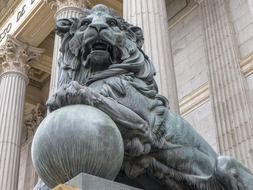 sculpture of a lion lying on a ball