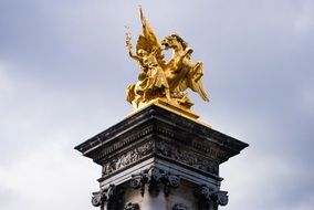 golden statue on the tower in paris