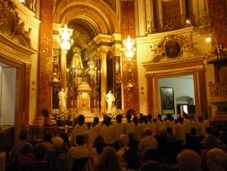 Mass in the church with gold trim in Valencia