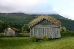 landscape of wooden farm among green hills