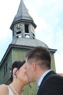 kissing young couple in front of old church