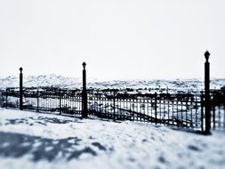 black iron fence on snow background