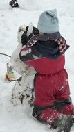 child sculpts snowman