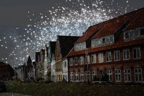 flashes of firework over the houses of the city of happiness