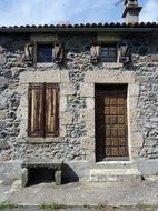 stone house with wooden shutters and door