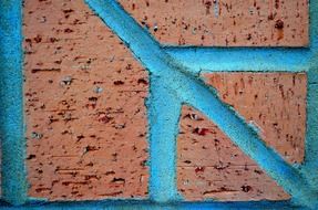 red brick wall with blue concrete stripes