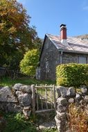 small house behind a stone fence in the countryside