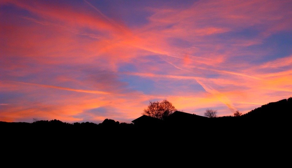orange clouds in the sky above houses during sunset