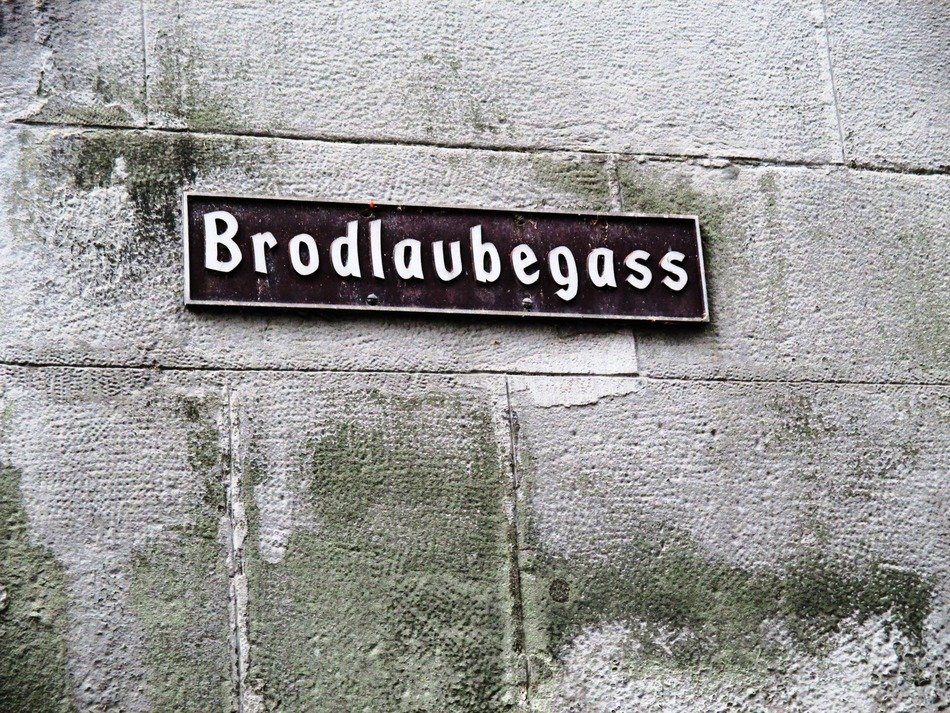 sign on a stone wall in the alley