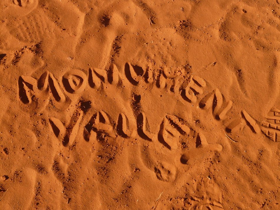 Monument Valley as an inscription on brown sand