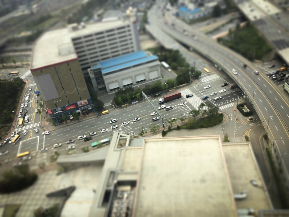 panoramic view of road among buildings in blurred background
