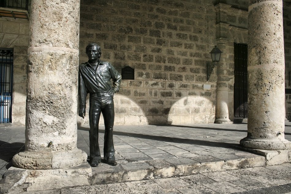 sculpture of man near the column in the city