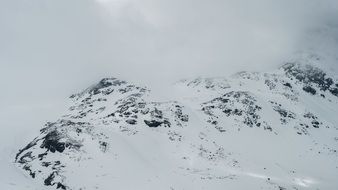 fog over a snowy mountain peak