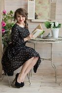 beautiful woman sitting by a coffee table reading a book