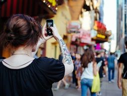 girl takes a picture of a city street on a mobile