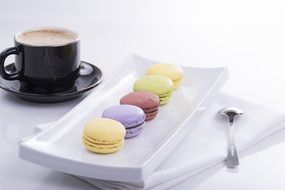 macaroon on a square plate and a cup of coffee