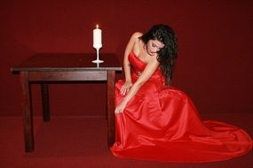 lady in red on a background of burning candle on a table