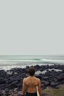 surfer muscular back man on the seashore