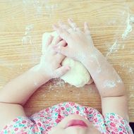 child girl plays with dough on table