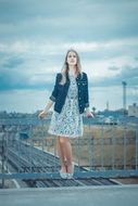 Girl posing on the fence of the bridge