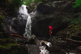 person with umbrella at waterfall