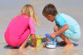 children play in the sand on the beach