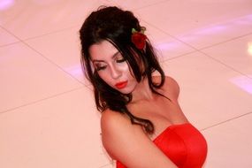 sensual girl in a red dress with a rose in her hair